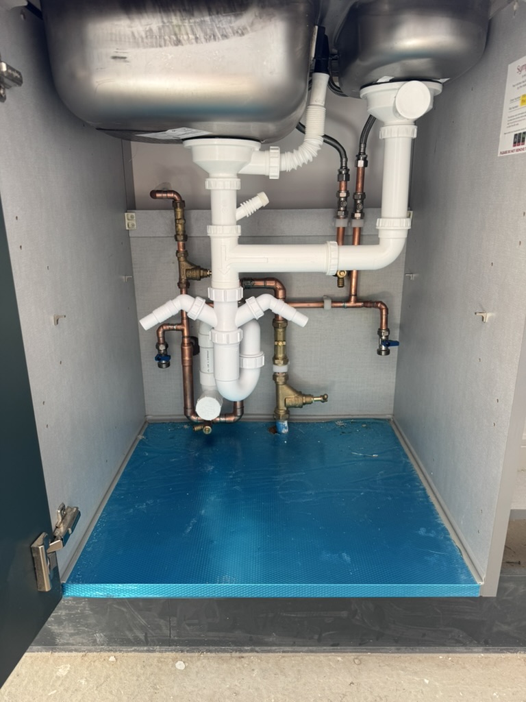 Twin-bowl kitchen sink waste and supply connections during installation